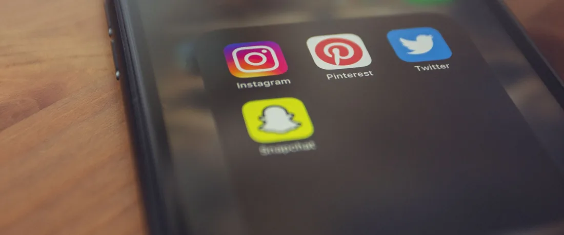 Écran de téléphone affichant les icônes Instagram, Pinterest, Twitter et Snapchat.