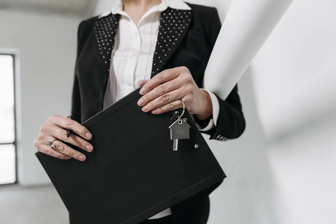 Dossier et clé de maison lors d'une visite immobilière.